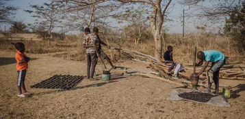 Menschen in Sambia stellen mit einfachen Mitteln Briketts aus verkohlten Pflanzenresten her